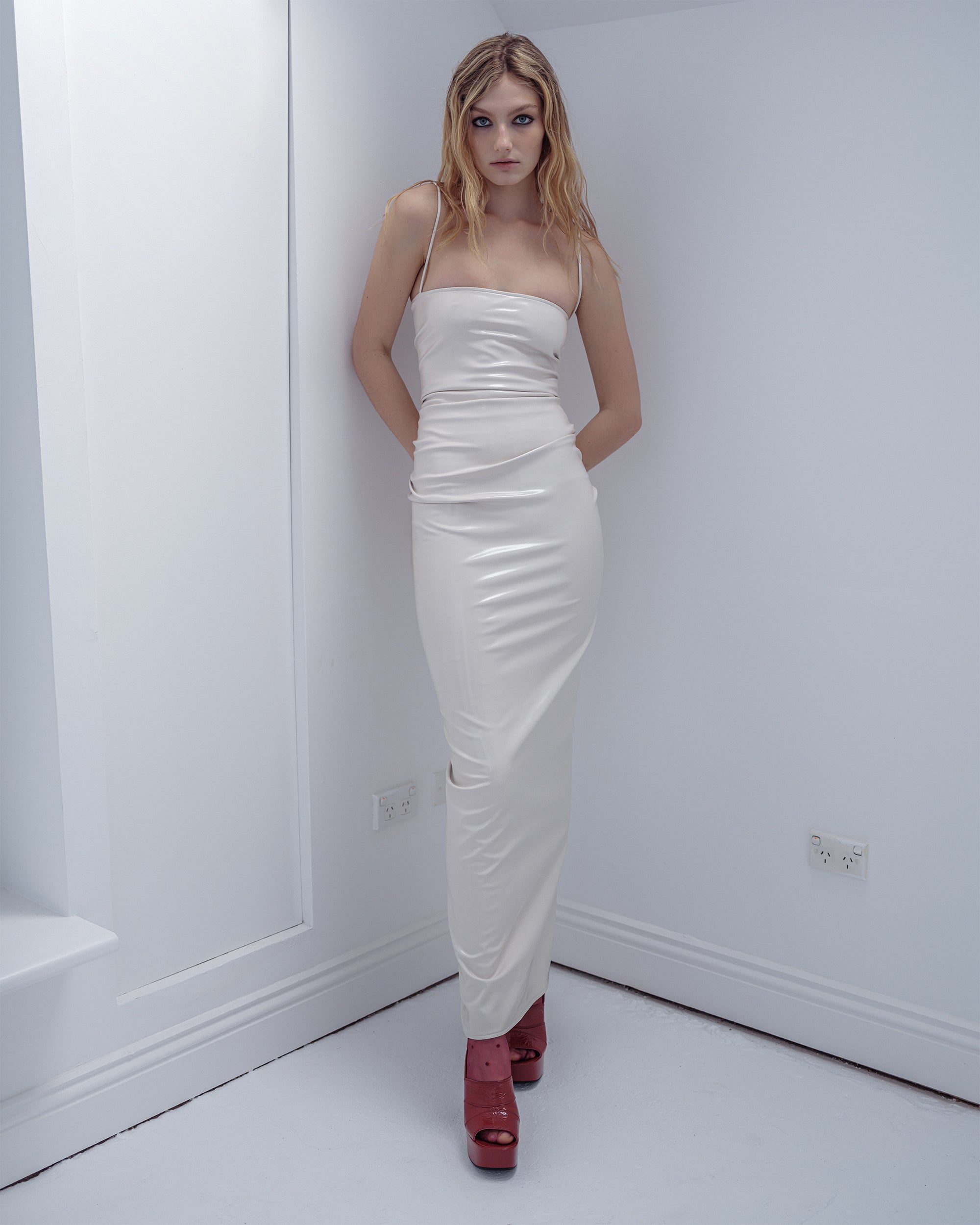 Woman in a white Vanilla Nip PVC dress from Common Hours.