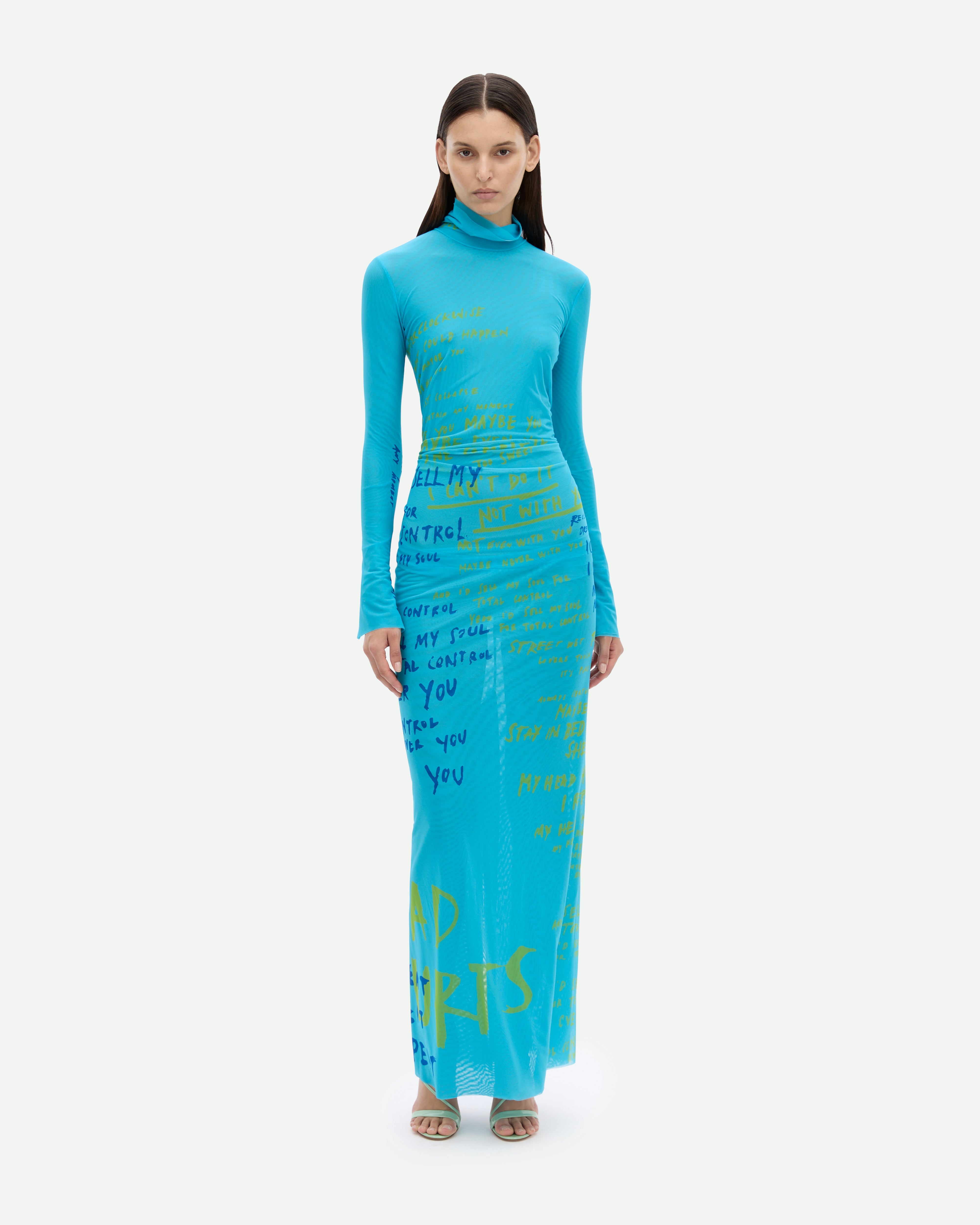 A long turquoise mesh dress with a placement print of lyrics of "Total Control" song by the Motel.