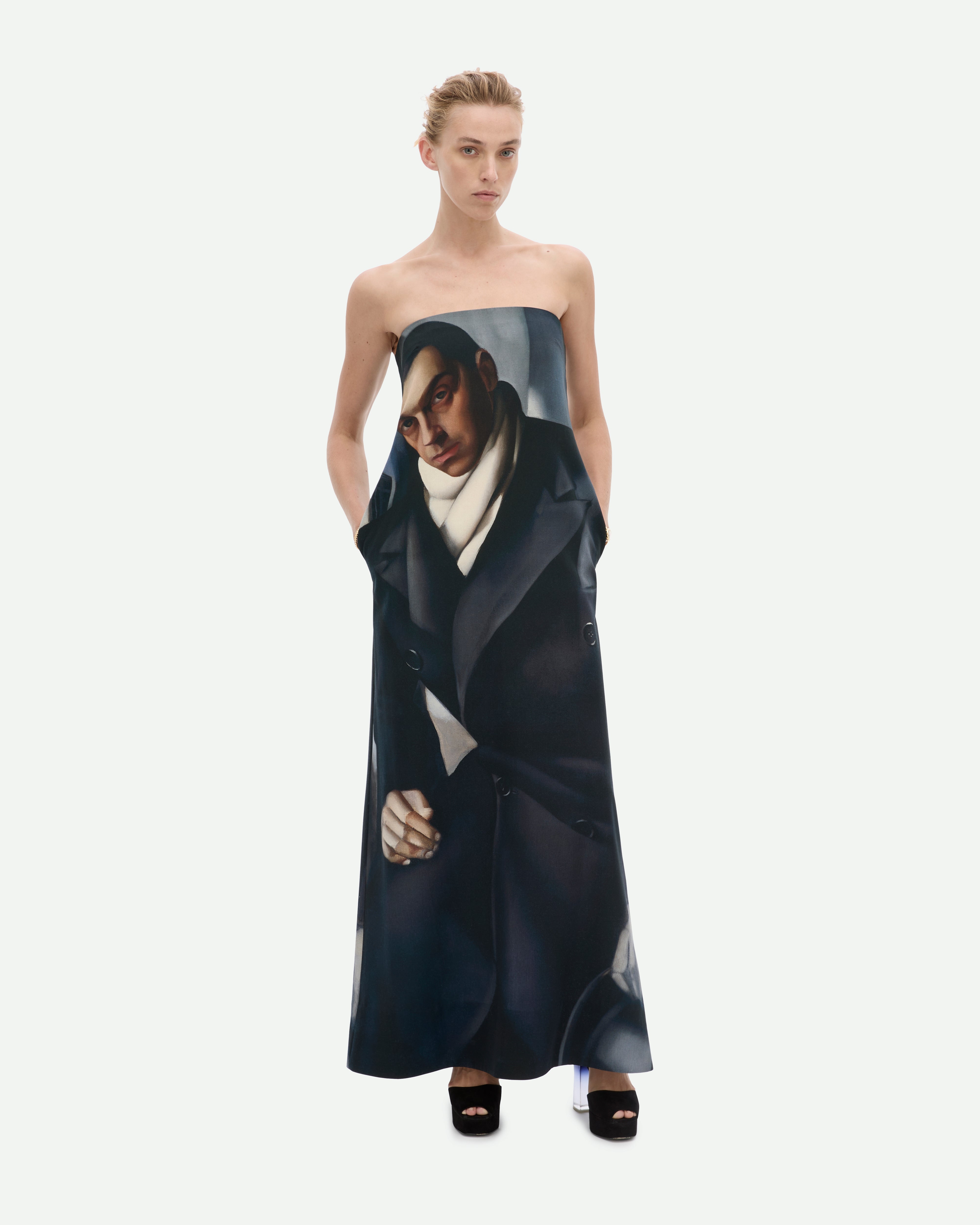 Woman in a long black strapless dress featuring a painting of a man by Common Hours.