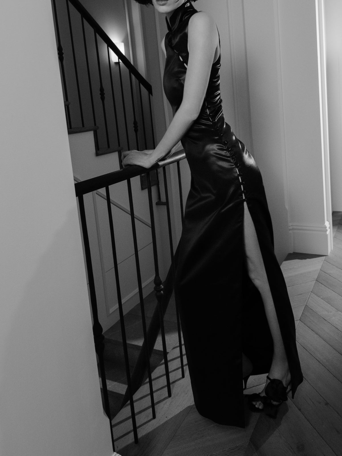 Devotion dress from Common Hours x Abbey Lee collection, in black satin with a thigh-high cutaway side split.