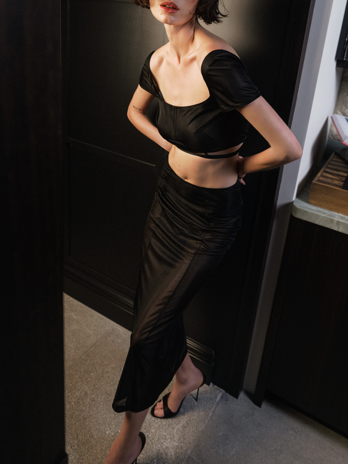 The Unfolding long skirt, in black semi-sheer stretch jersey from Common Hours x Abbey Lee collection.