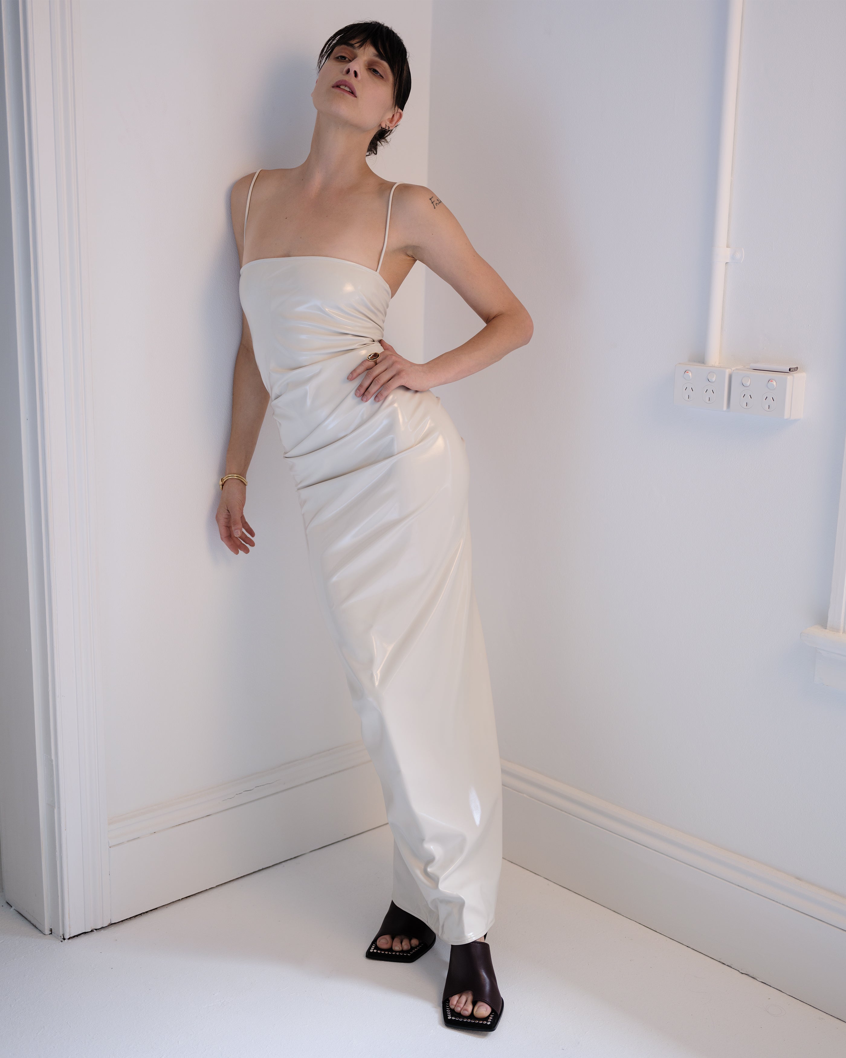 Woman in a white Vanilla Nip PVC dress from Common Hours.