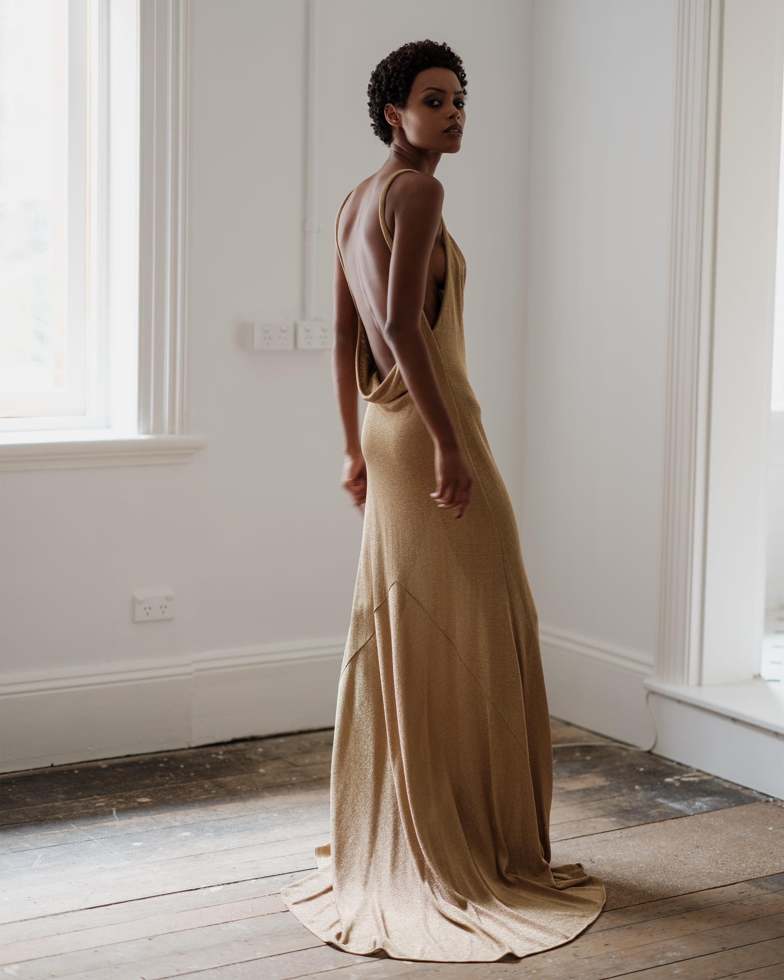 Long, flowing gold metallic dress with open back, Common Hours Prohibition dress.