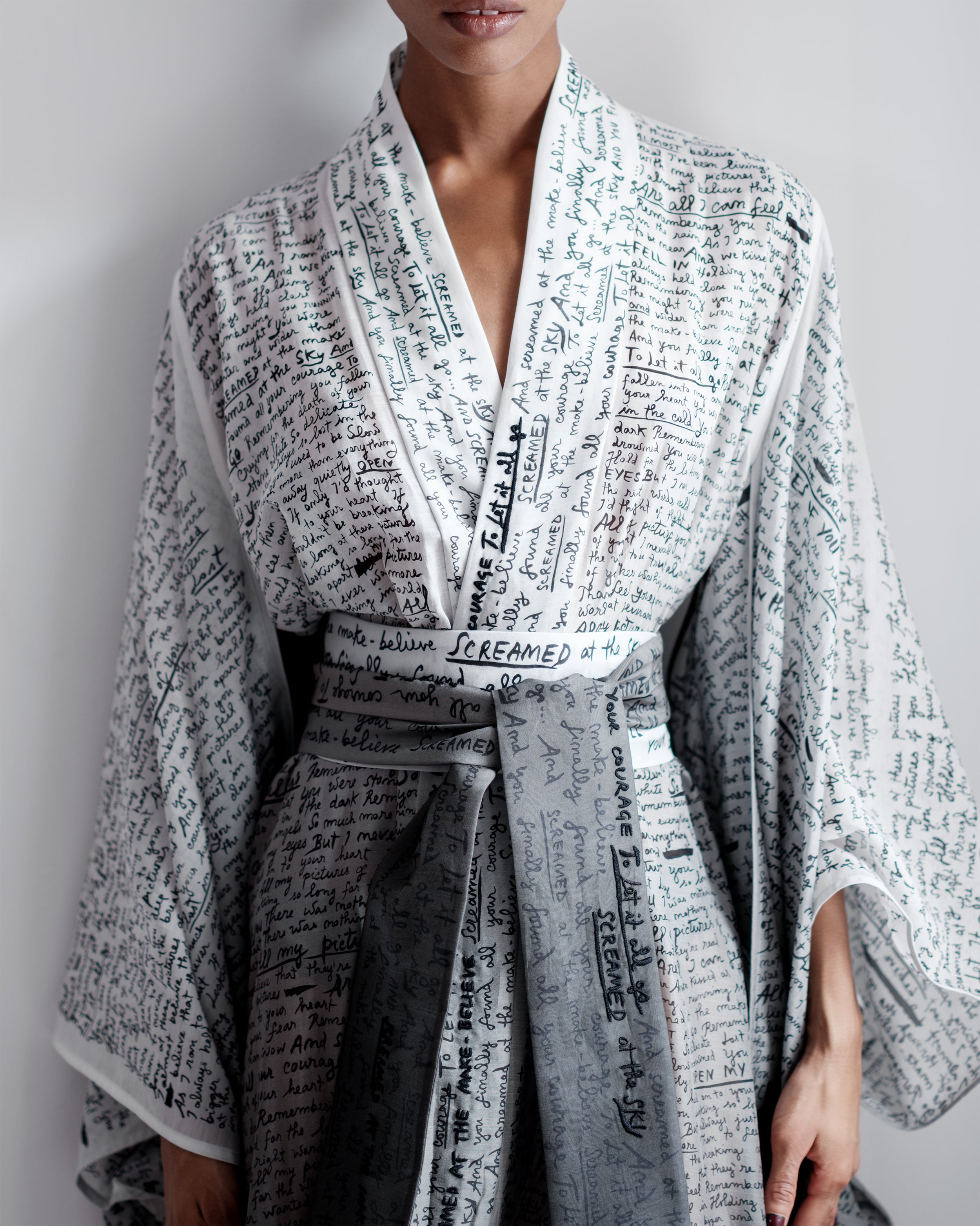 Woman wearing a Common Hours gradient robe dress with printed and hand-embroidered words