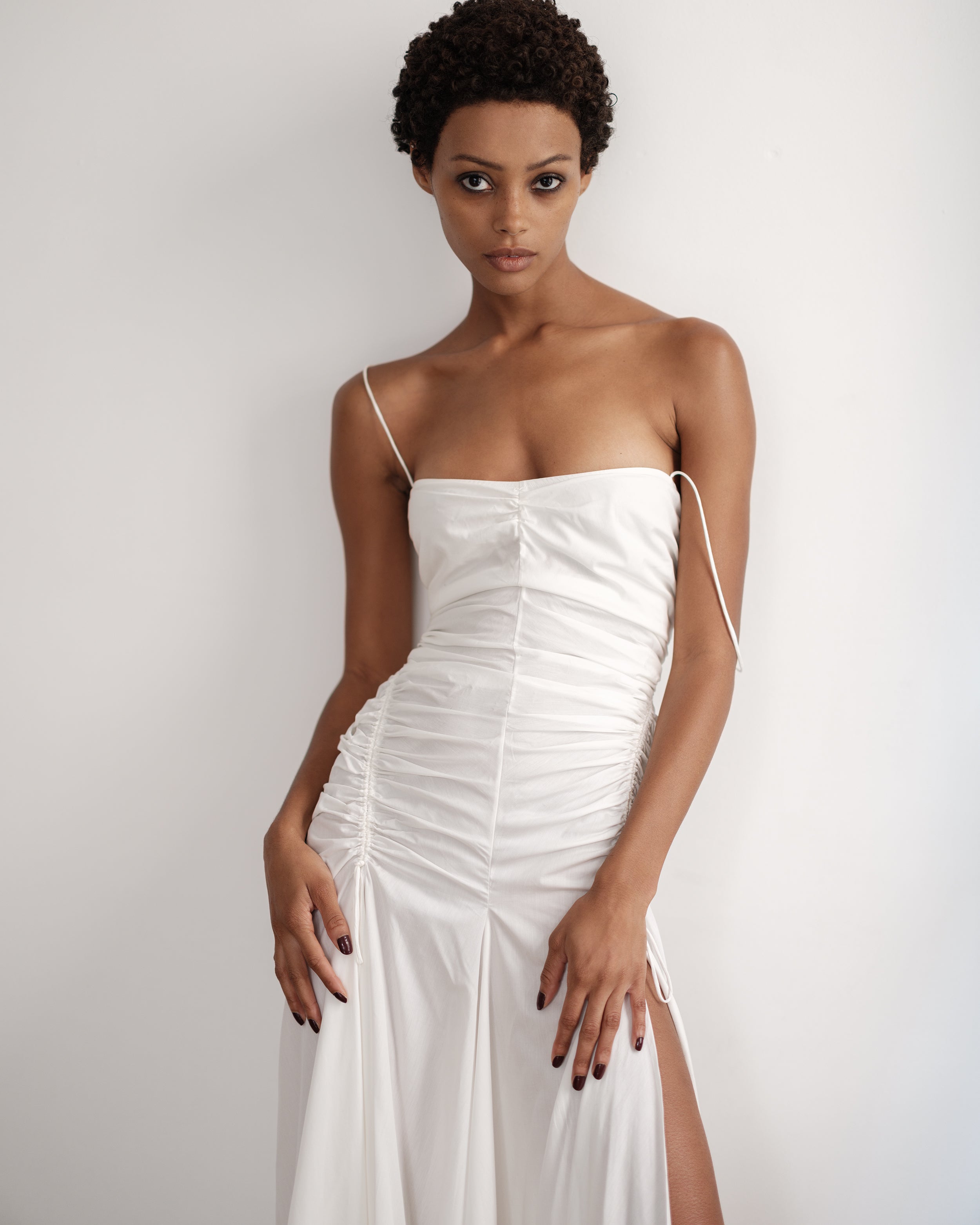 Woman wearing a white cotton dress Three Points of Majesty by Common Hours.