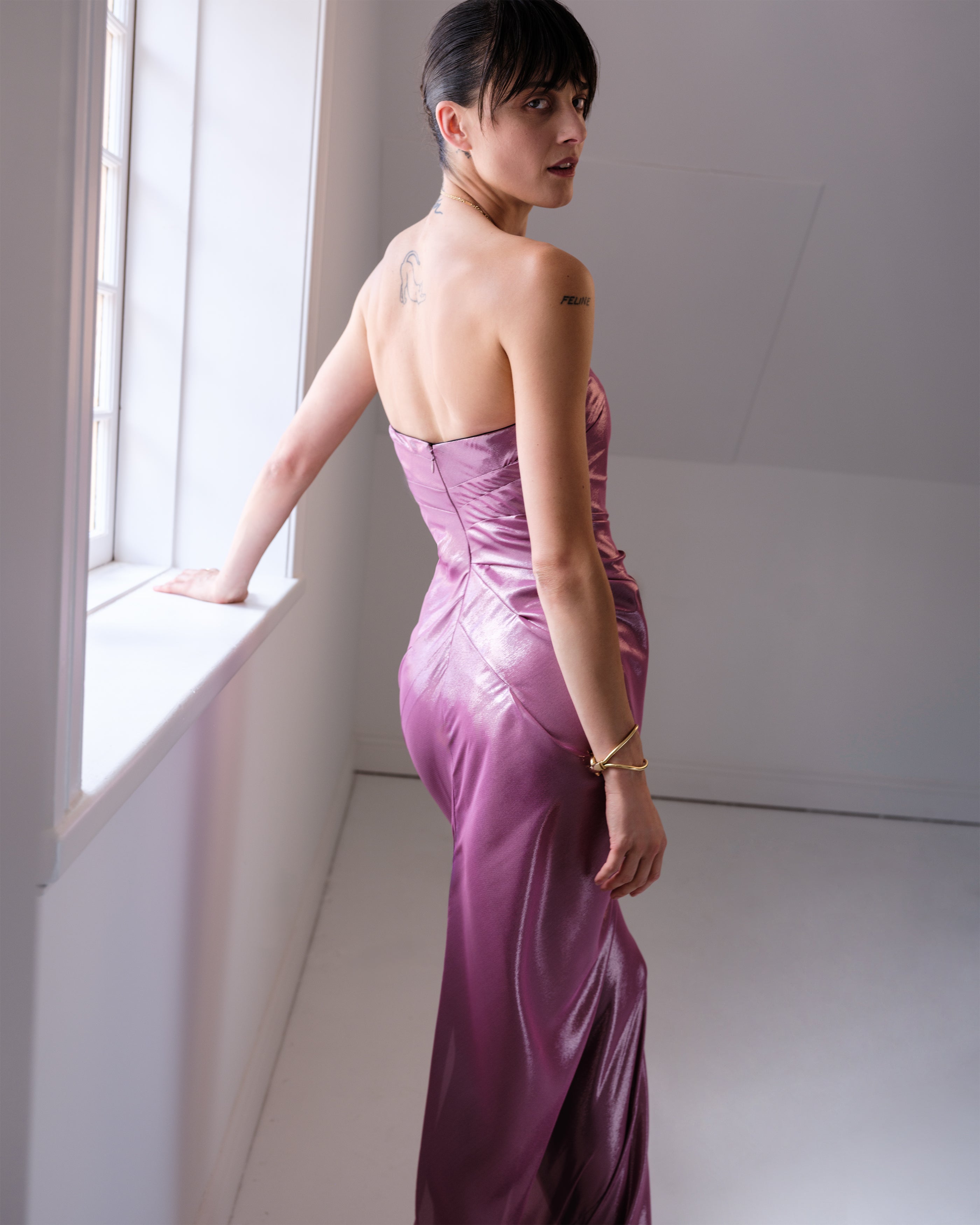 Woman in a strapless purple metallic Injustice dress by Common Hours.