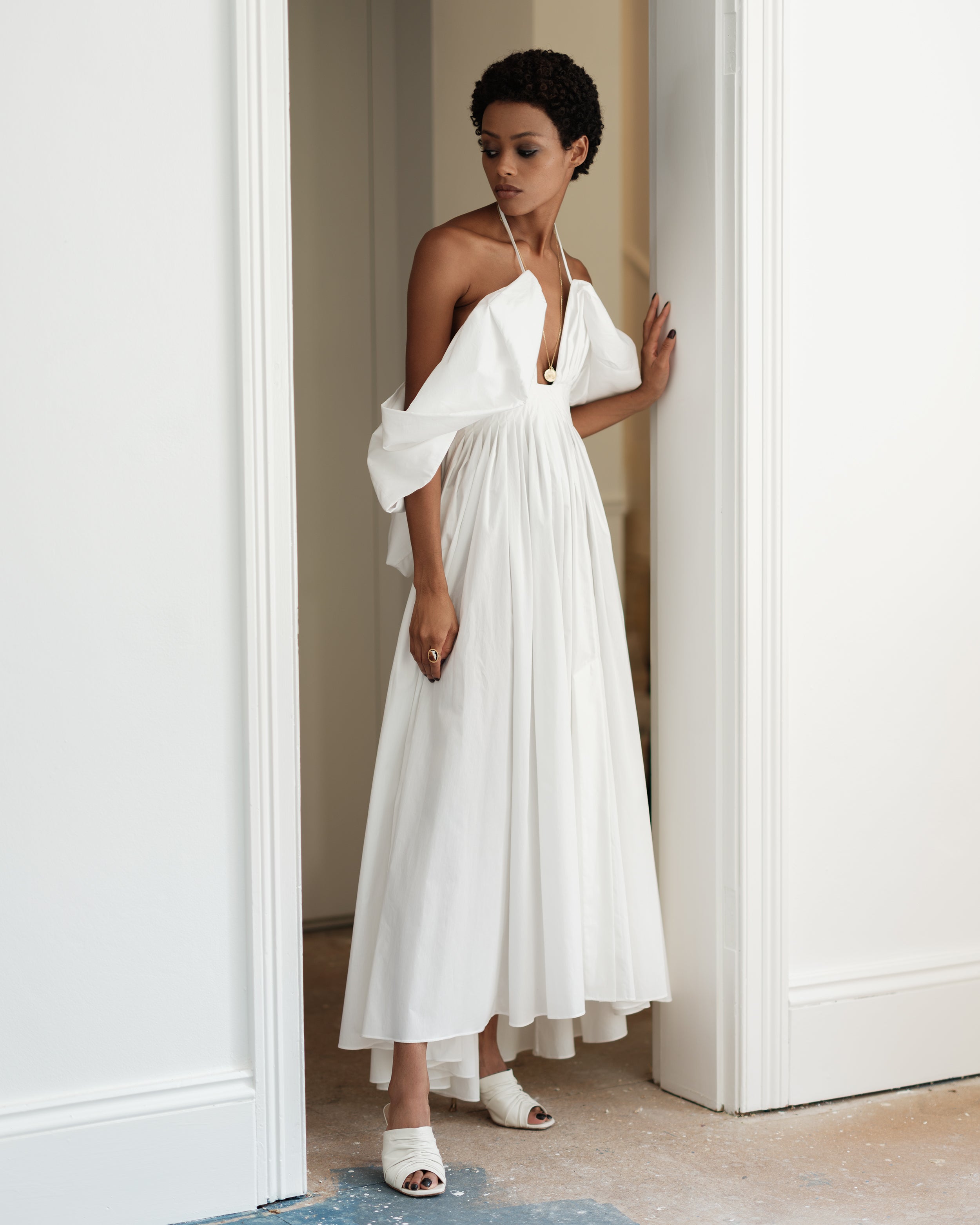 Woman in a white puffy sleeve dress Rounding Errors by Common Hours. Summer cotton dress.